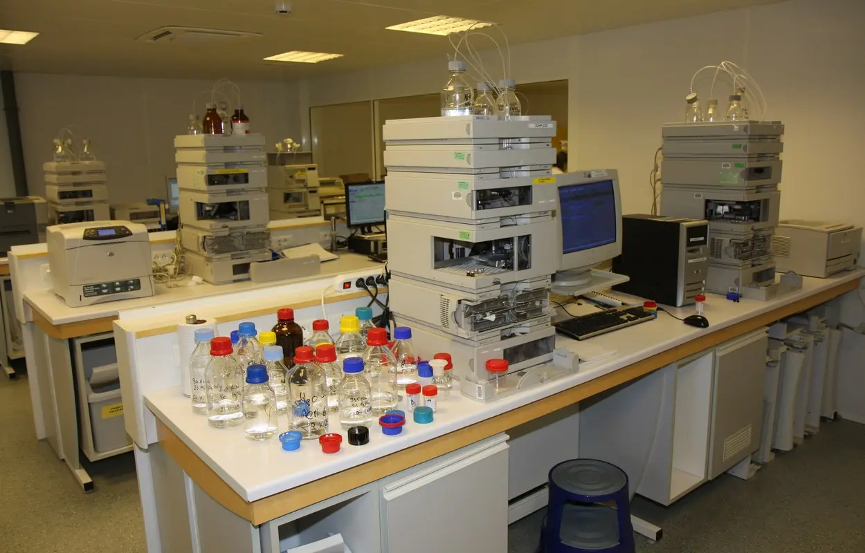 Equipos de cromatografía líquida en un laboratorio de control farmacéutico. Root66, CC BY-SA 3.0. Origen: https://commons.wikimedia.org/wiki/File:Laboratoires_Arkopharma_-_Laboratoire_de_controle_-_Chromatographie_liquide.JPG